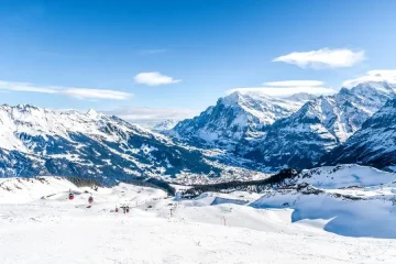 Alpes Suíços: paisagem de inverno com montanhas nevadas, teleféricos e céu azul. Roteiros de esqui e trilhas incríveis.