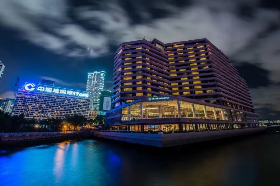 Hotel InterContinental iluminado à noite. Arquitetura moderna, reflexos na água. Viagem de luxo, conforto.