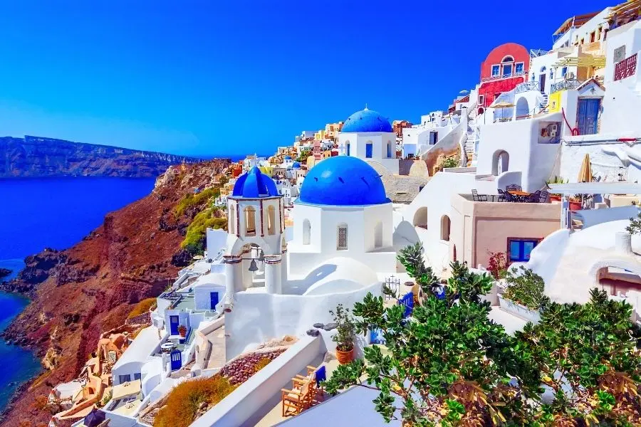 Santorini, Grécia: Vista panorâmica das casas brancas e igrejas com cúpulas azuis. Paisagem deslumbrante da ilha.