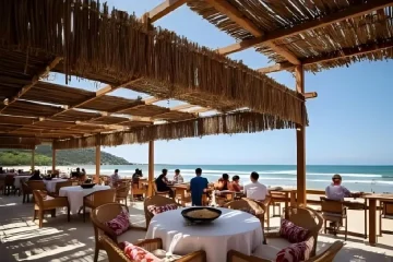 Restaurante Uxua Praia Bar à beira-mar. Experiência gastronômica, mesas elegantes, vista oceânica. Refeição luxuosa.